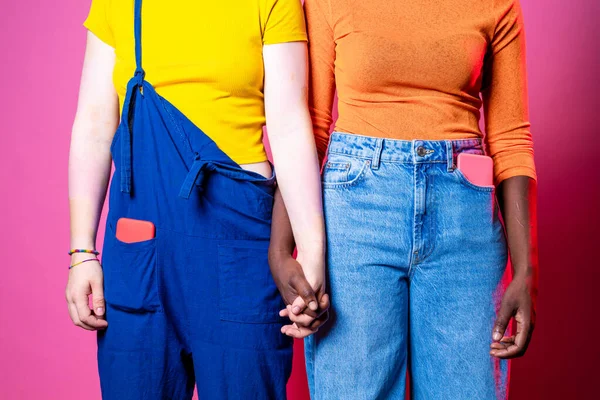多様な黒人女性と白人女性が手を携えて ピンクを背景に人種差別に立ち向かう二人の多民族女性 多様性 包容力 女性らしさの概念 — ストック写真