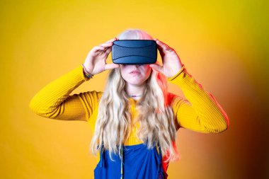 Yeşil arka planda VR gözlükleri kullanan beyaz bir kadın - fütürist kulaklık takan yalnız beyaz bir kadın - eğlence, teknoloji, fütürist konsept