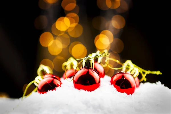 Röda Julgranskulor Snön Med Guld Och Suddig Bokeh Bakgrund — Stockfoto