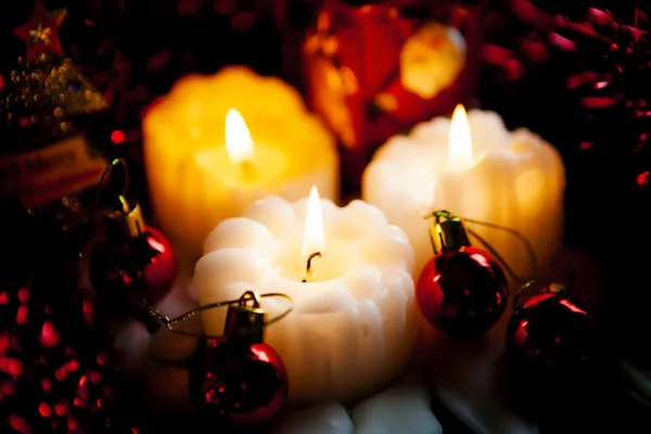 装飾の赤のボールと背景をぼかした写真お祭りに燃えてクリスマスキャンドル暖かい光 — ストック写真
