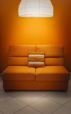 Turuncu kanepe ve duvar lamba yukarıdaki ve yastık ile