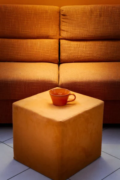 橙色沙发特写镜头与 Pouf 和大杯子 — 图库照片