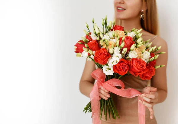 美しい女性が幸せな笑顔灰色の背景の赤とピンクのバラの花束を保持します — ストック写真