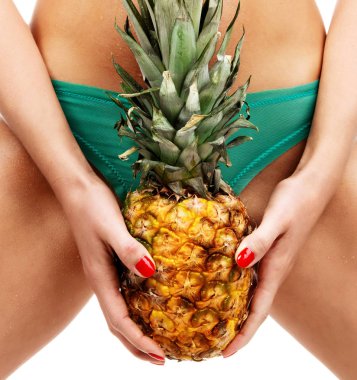 Seksi kadın vücut üzerinde beyaz izole elinde olgun ananas meyve tutun