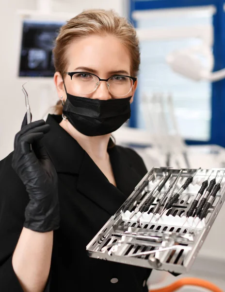 Kobieta lekarz dentysta chirurg z narzędzi medycznych, stojąc w dental — Zdjęcie stockowe