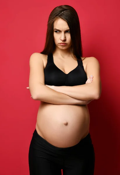 Unga gravida lyckliga modern kvinna arg titta i hörnet på rött — Stockfoto