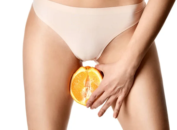 Ginecología cuidado del cuerpo y la salud de la mujer. De cerca foto de la mano de la mujer mantenga fruta naranja cerca de la parte íntima — Foto de Stock