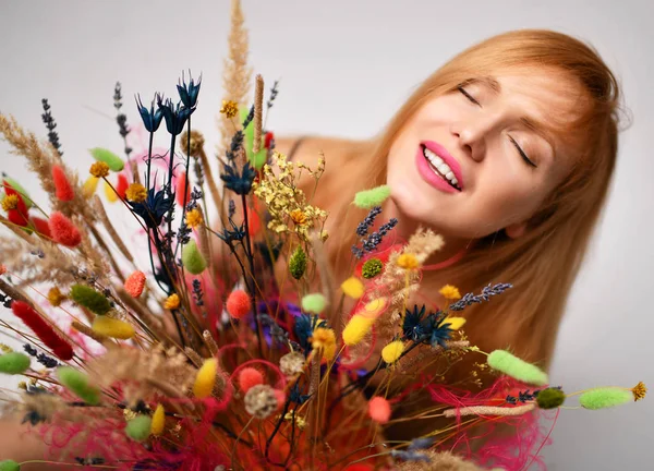 Красива жінка посміхається з букетом диких квітів крупним планом портрет щасливий усміхнений вид зверху на сірий — стокове фото