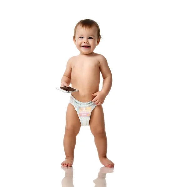Младенец ребенок девочка ребенок в подгузнике сделать первые шаги с мобильного телефона изолированы на белом — стоковое фото