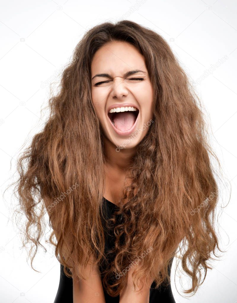 Curly brunette woman happy laughing excited looking up with closed eyes