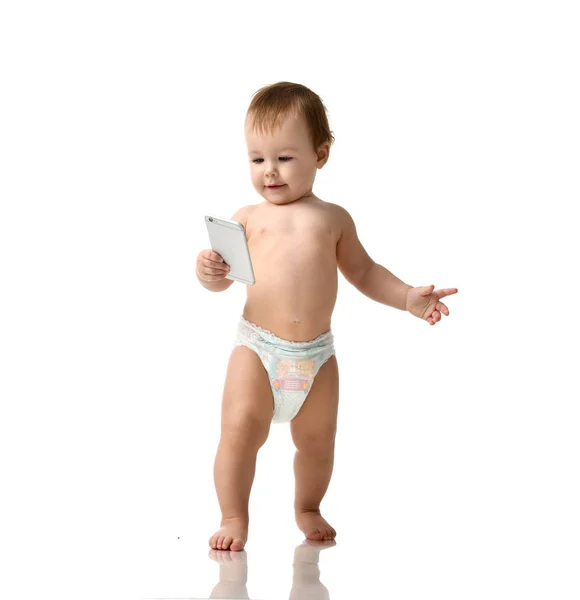 Infant child baby girl kid toddler in diaper  make first steps with mobile cellphone isolated on a white — Stock Photo, Image
