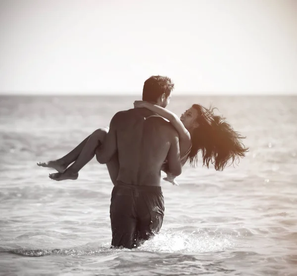 Feliz casal alegre se divertindo abraçando correndo no mar juntos. Férias românticas, amor de lua de mel — Fotografia de Stock