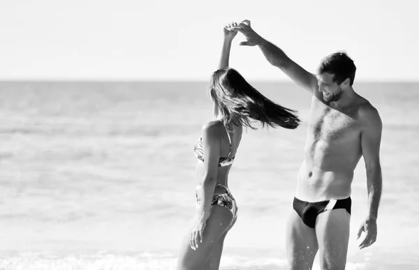 Feliz casal alegre se divertindo dançando correndo no mar juntos. Férias românticas, amor de lua de mel — Fotografia de Stock