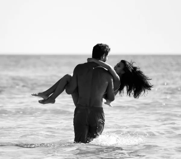 Ευτυχισμένο ζευγάρι χαρούμενα διασκεδάζοντας αγκάλιασμα τρέχει στη θάλασσα μαζί. Ρομαντικές διακοπές, μήνα του μέλιτος αγάπη — Φωτογραφία Αρχείου