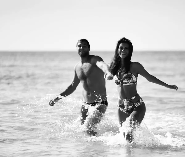 Ευτυχισμένο ζευγάρι χαρούμενα κρατήστε hans και τρέχει στη θάλασσα μαζί. Ρομαντικές διακοπές, μήνα του μέλιτος αγάπη — Φωτογραφία Αρχείου