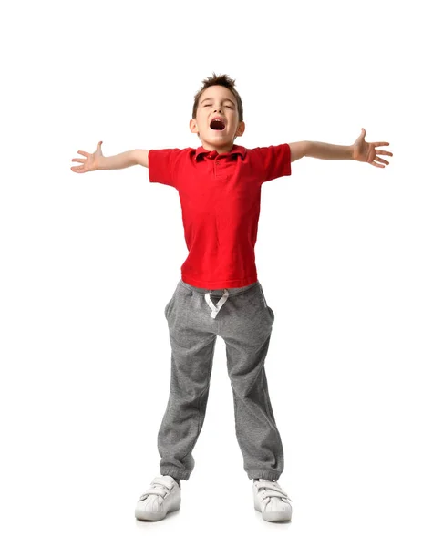 Jongen jongen in rode t-shirt en grijs broek verspreid handen omhoog gelukkig lachend schreeuwende lachen geïsoleerd op wit — Stockfoto