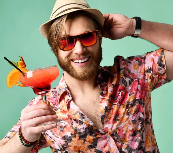 Şapka ve güneş gözlüğü margarita kokteyl içki suyu üzerinde açık yeşil gülüyor kamera bakarak mutlu içme genç adam — Stok fotoğraf