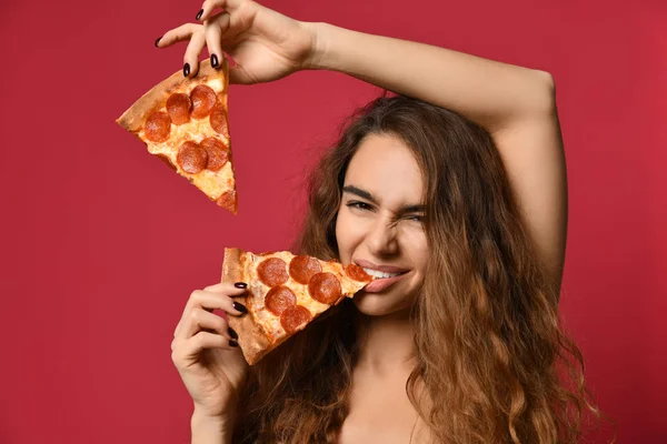 Giovane bella donna mangiare fetta di pizza salame piccante su rosa rosso — Foto Stock