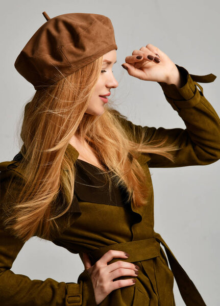 Young sexy brunette woman in brown beret hat looking at the corner 