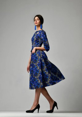 Yeni mavi model rahat office elbise gri arka plan üzerinde yürüyen kadın