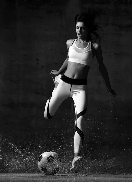 Piłka nożna kobieta gracz skacze i uderzył piłkę wrzask krzyczy na mur beton loft — Zdjęcie stockowe