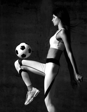 Kadın futbolcu atlar ve Orta Beton çatı duvar topu grev vurmak 