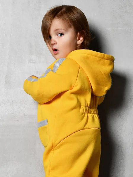 Bebek Çocuk bebek kız çocuk gri duvar sarı kostüm — Stok fotoğraf