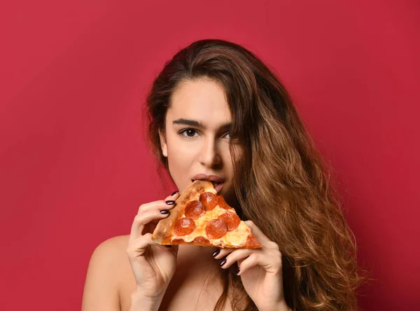 Mooie jongedame eten plak van pizza pepperoni met gesloten ogen glimlachend op rood roze — Stockfoto