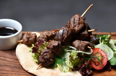 Lezzetli Barbekü sığır eti taze sebze ile ahşap plaka üzerinde şaşlık ve Sigara Buhar