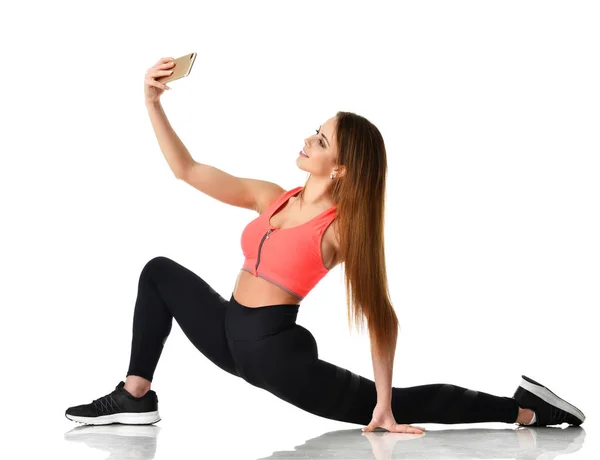 Sport gimnastyka kobieta robi wyciąganie fitness ćwiczenie i zrobić selfie na jej telefon komórkowy mobile — Zdjęcie stockowe