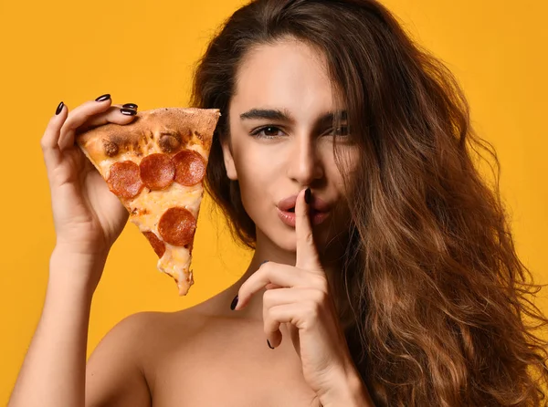 Giovane bella donna tenere fetta di pizza salame piccante e spettacolo tss abbastanza cantare sul giallo — Foto Stock