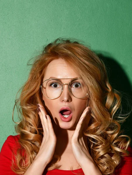 Woman surprised shouts holds cheeks by hand in clear glasses. Expressive facial expressions — Stock Photo, Image