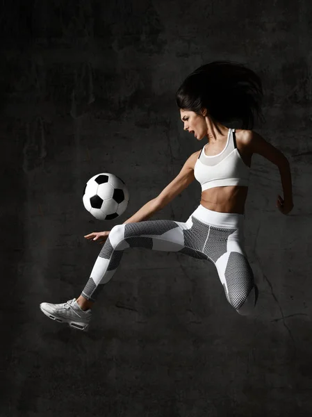 Woman player run jump and hit soccer ball yelling screaming with dust splashes — Stock Photo, Image