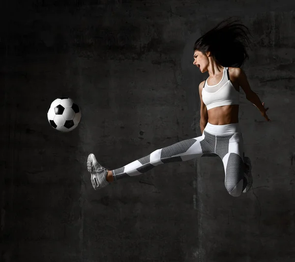 Γυναίκα παίκτη που τρέχει άλμα και χτύπημα ποδόσφαιρο μπάλα φωνάζει ουρλιάζοντας με πιτσιλιές σκόνη — Φωτογραφία Αρχείου