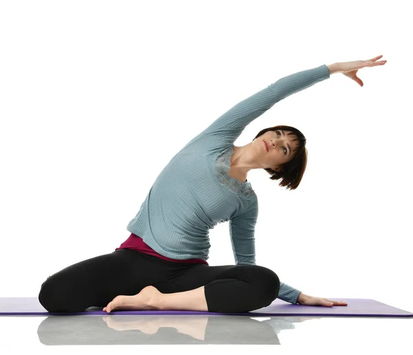 Female fitness instructor doing stretching for hands legs abdominals bar exercise in gym work out isolated on white — Stock Photo, Image