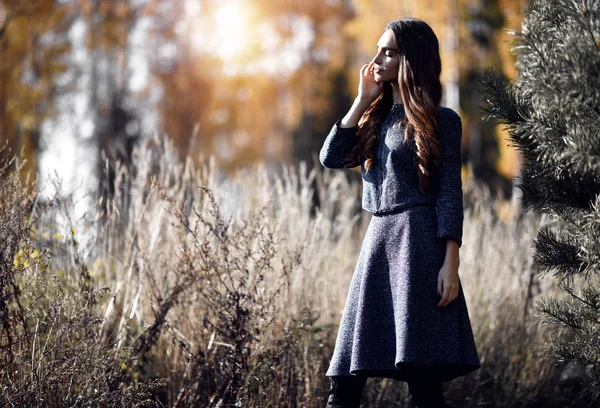 Woman wearing warm autumn dress in the park at sunny autumn day — Stock Photo, Image