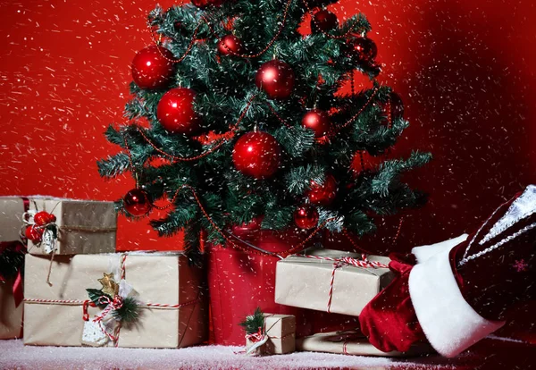 Albero di Natale decorato con palline di ornamento patchwork rosso e mani di Babbo Natale mettere mestiere regali — Foto Stock
