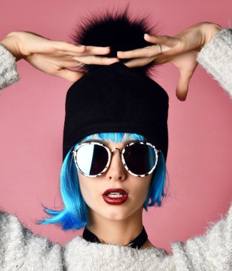 Genç grunge tarzı kadın mavi peruk saç siyah zinciri gerdanlık boyun ve pembe üzerinde siyah şapka ile 