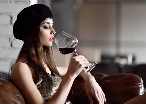 Hermosa mujer usar sombrero gorra de invierno negro beber vino tinto en restaurante caro — Foto de Stock