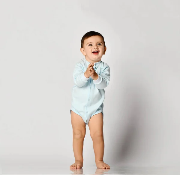 Kind kind baby jongen kind peuter in licht blauw lichaam doek maken eerste stappen op grijs — Stockfoto