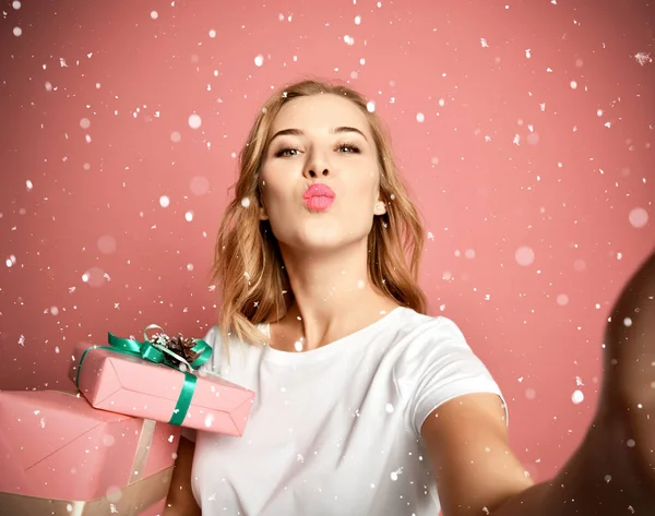 Ung vacker kvinna håll presenter julklappar leende och göra selfie foto med sin mobiltelefon mobil — Stockfoto