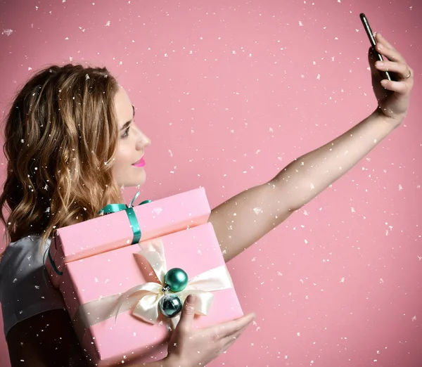 Jovem bela mulher segurar Natal apresenta presentes sorrindo e fazer foto selfie com seu celular móvel — Fotografia de Stock