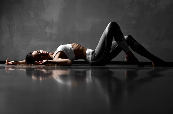 Femeia sport pozând întinsă pe podea în pânză sport elastică cu ochi închiși — Fotografie, imagine de stoc