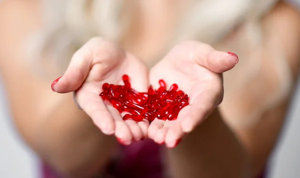 Femme tenir rouge capsules cosmétiques soin de la peau traitement sérum capillaire dans les mains — Photo