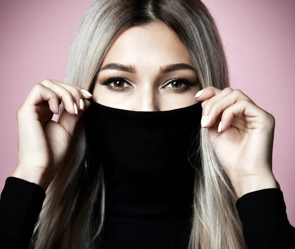 Closeup portret van mooie vrouw verbergen lippen en neus in zwarte trui keel — Stockfoto