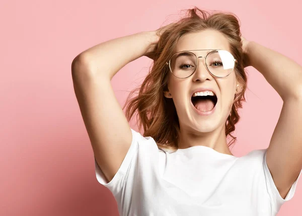 Mulher feliz emocional em óculos gritando gritando gritando closeup retrato no fundo rosa — Fotografia de Stock