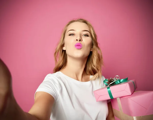 Jeune belle femme tenir cadeaux de Noël présents souriant et faire selfie photo avec son téléphone portable mobile — Photo