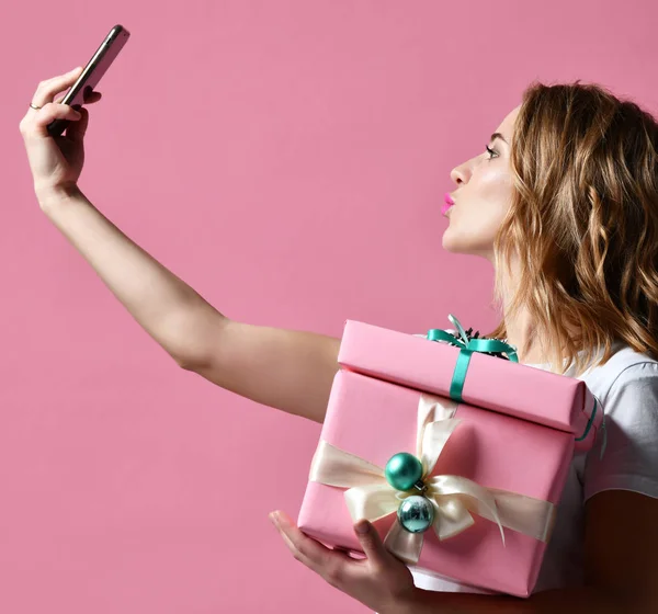 Genç güzel kadın Noel mevcut hediyeler gülümseyen tutun ve selfie fotoğraf ile cep telefonunu Mobil olun — Stok fotoğraf