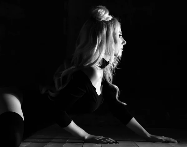 Giovane donna sexy bionda di moda seduta sul pavimento in tessuto nero del corpo e girocollo — Foto Stock