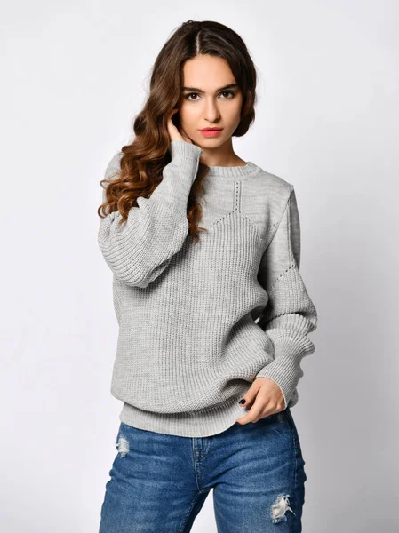 Mladá krásná žena pózuje v nové příležitostné šedou halenku svetr — Stock fotografie